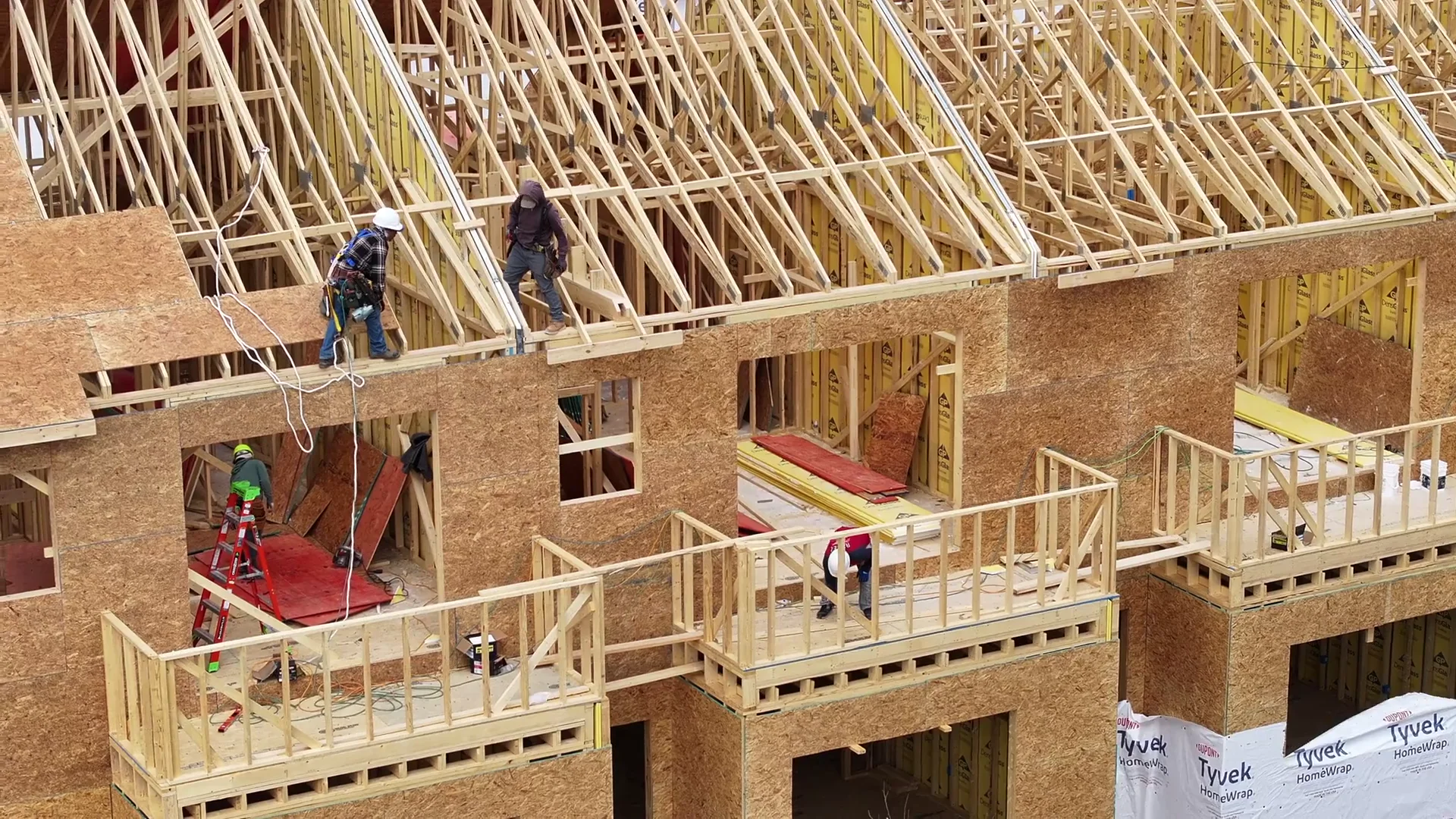 Workers assembling residential timber framing; construction reference footage